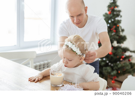 Father helps to put on cochlear implant for his deaf baby daughter in christmas living room copy space. Diversity and hearing aid and innovating medical technologies treatment deafness concept Father helps to put on cochlear implant for his deaf baby daughter in christmas living room copy space. Diversity and hearing aid and innovating medical technologies treatment deafness concept 90040206