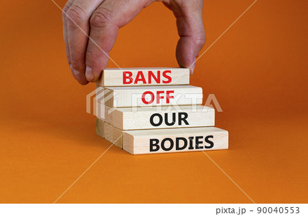 Bans off our bodies symbol. Concept words Bans off our bodies on wooden blocks on beautiful orange table orange background. Women rights concept. Business social issues bans off our bodies concept. 90040553