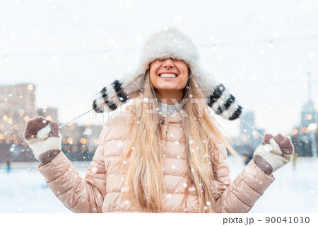Happy winter time in big city charming girl standing street dressed funny fluffy hat. Enjoying snowfall, expressing positivity, smiling to camera Happy winter time in big city charming girl standing street dressed funny fluffy hat. Enjoying snowfall, expressing positivity, smiling to camera 90041030