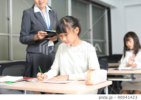 勉強をする女子学生と塾講師のイメージ 勉強をする女子学生と塾講師のイメージ 90041423