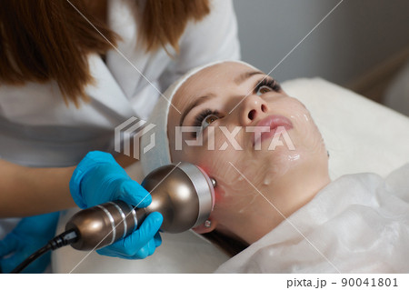 LED light anti-aging mask for facial skin care in a spa slow motion. A woman lies on a couch in a special mask. Modern technologies of beauty and health. LED light anti-aging mask for facial skin care in a spa slow motion. A woman lies on a couch in a special mask. Modern technologies of beauty and health. 90041801