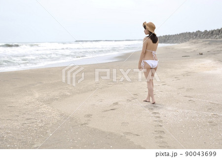 九十九里の海岸を散歩する白いビキニ姿の若い女性 九十九里の海岸を散歩する白いビキニ姿の若い女性 90043699