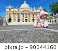 Baby girl sitting on a european city street. Little child outdoors in a town. 90044160