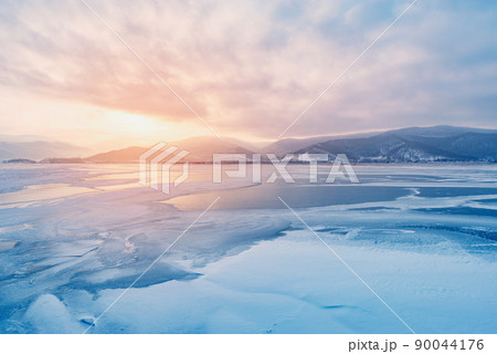 Frozen surface of Baikal lake at sunset. 90044176