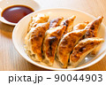食卓の焼きたてで美味しそうなたれ付き餃子 90044903