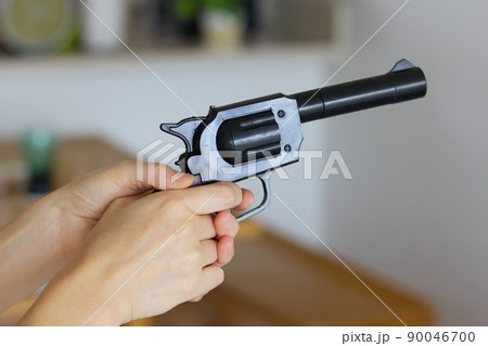 自宅で銃をにぎる女性の手元 90046700
