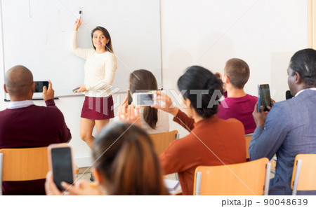 Businesswoman advertises product in front of an audience Businesswoman advertises product in front of an audience 90048639