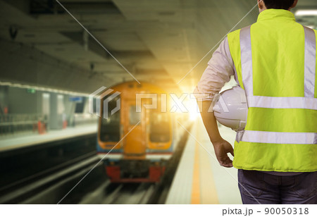 Engineer railway under checking construction process train testing and checking railway work on railroad station with radio communication .Engineer wearing safety uniform and safety helmet in work. Engineer railway under checking construction process train testing and checking railway work on railroad station with radio communication .Engineer wearing safety uniform and safety helmet in work. 90050318