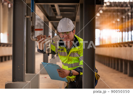 Engineer railway under  checking construction process train testing and checking railway work on railroad station with radio communication .Engineer wearing safety uniform and safety helmet in work. 90050350