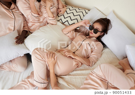 Cool Young Woman Lying on Bed 90051433