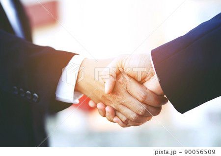 Closeup of a businessman hand shake investor between two colleagues OK, succeed in business Holding hands. Closeup of a businessman hand shake investor between two colleagues OK, succeed in business Holding hands. 90056509