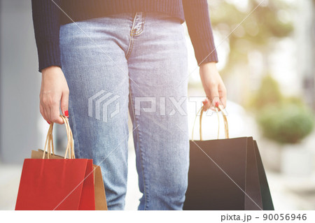 Close up of consumerism young woman holding hand many shopping bag in fashion boutique after buying presents while walking along the street with copy space , enjoying summer sale and people concept Close up of consumerism young woman holding hand many shopping bag in fashion boutique after buying presents while walking along the street with copy space , enjoying summer sale and people concept 90056946