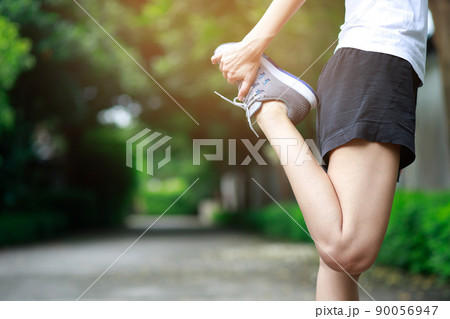 young female runner stretching for warming up before running or working out on the park. Track and Field Athlete exercise. Fitness and sport healthy lifestyle concept. young female runner stretching for warming up before running or working out on the park. Track and Field Athlete exercise. Fitness and sport healthy lifestyle concept. 90056947