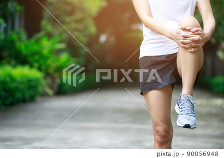 young female runner stretching for warming up before running or working out on the park. Track and Field Athlete exercise. Fitness and sport healthy lifestyle concept. 90056948