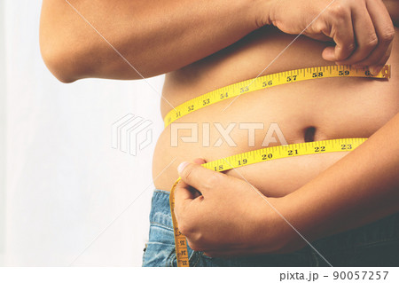 fat man check out body overweight abdomen his belly with in hand measuring tape f fat man check out body overweight abdomen his belly with in hand measuring tape f 90057257