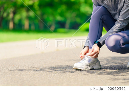 トレーニング前に靴紐を結ぶ女性 運動 ジョギング トレーニング前に靴紐を結ぶ女性 運動 ジョギング 90060542