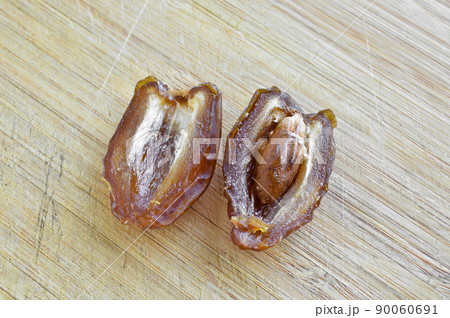 Organic fresh nutritious dried hurma dates medjool grains, on cutting board 90060691