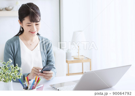 携帯電話を操作する女性 携帯電話を操作する女性 90064792
