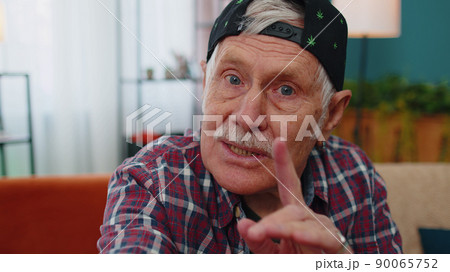 POV of senior grandfather making online video call talking waving hand looking at camera at home POV of senior grandfather making online video call talking waving hand looking at camera at home 90065752