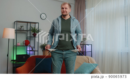 Upset poor man showing empty pockets inside out, having no money, bankruptcy, debts, poverty problem Upset poor man showing empty pockets inside out, having no money, bankruptcy, debts, poverty problem 90065973