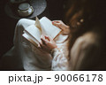 紅茶を飲みながら読書をするドレスを着た女性 90066178