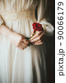 赤い薔薇を持つドレスを着た女性 90066179