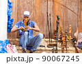 afro american man working on his sculptures in the street 90067245