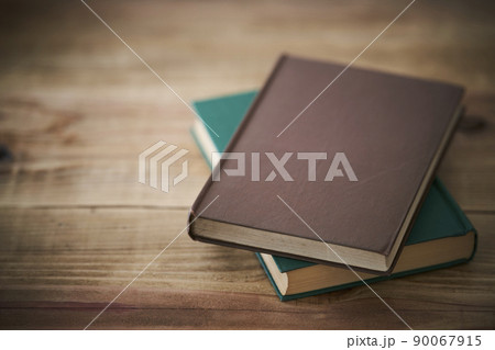 古い机に置かれた茶色い表紙の本 90067915
