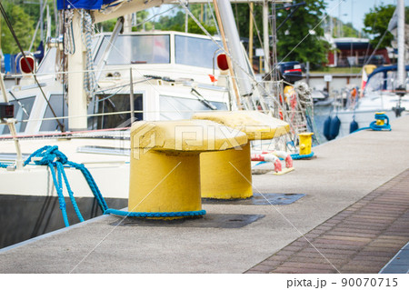Thick rope and yellow bollards on wharf using for anchorage of yachts 90070715