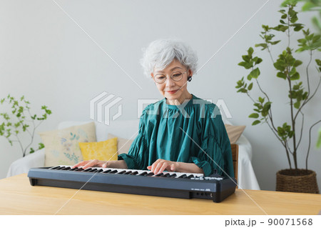 リビングでキーボードを弾くグレイヘアの女性 リビングでキーボードを弾くグレイヘアの女性 90071568