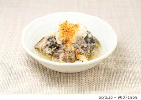 サンマの醤油煮缶詰で一品料理,たっぷりの大根おろしに七味唐辛子をかける サンマの醤油煮缶詰で一品料理,たっぷりの大根おろしに七味唐辛子をかける 90071868