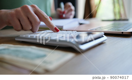 Businesswoman hand using calculator and working with laptop Businesswoman hand using calculator and working with laptop 90074017