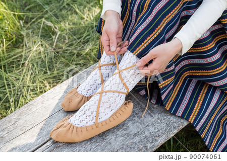 Leather bast shoes of a Latvian woman in traditional clothing. Preparing Ligo festival. Riga. Latvia 90074061