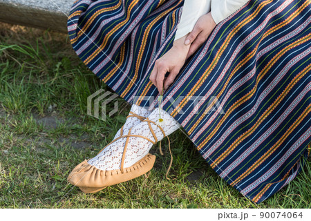 Leather bast shoes of a Latvian woman in traditional clothing. Preparing Ligo festival. Riga. Latvia 90074064