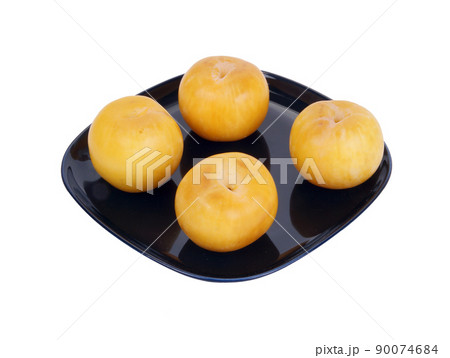 Yellow plums on a dark blue plate, isolated on a white background Yellow plums on a dark blue plate, isolated on a white background 90074684