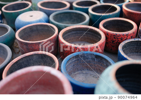 Multicolored old empty clay pots. Decorative ornament of ancient potter Multicolored old empty clay pots. Decorative ornament of ancient potter 90074964