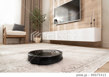 Robotic vacuum cleaner on the floor in cozy modern living room 90075415