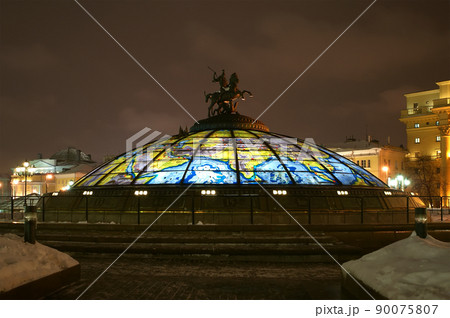 Glass cupola crowned by a statue of Saint George, holy patron of Moscow, with the Manege looming in the background , winter's night, Moscow, Russia 90075807
