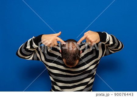 Human alopecia or hair loss - adult man hands pointing at his bald head isolated on blue studio background. Human alopecia or hair loss - adult man hands pointing at his bald head isolated on blue studio background. 90076443