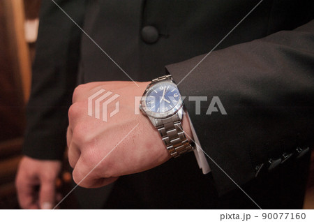 Businessman looking at his watch punctuality Businessman looking at his watch punctuality 90077160
