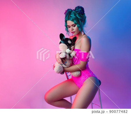 sexy girl with blue hair and pink bodysuit sitting on a bar stool on a neon background sexy girl with blue hair and pink bodysuit sitting on a bar stool on a neon background 90077482