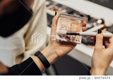 Makeup Artist Holding Brush and Shadows for Day Make Up in the Beauty Salon 90078474