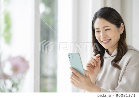 スマートフォンを持った笑顔のアラフィフの女性 スマートフォンを持った笑顔のアラフィフの女性 90081371