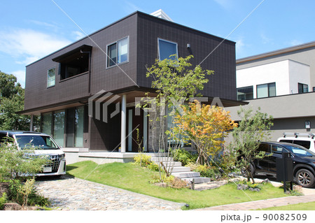 青空に映える箱型のモダンでスタイリッシュでおしゃれな落ち着いた高級感のある美しい瀟洒な邸宅 90082509