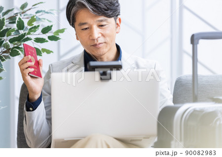 出張中に外出先のソファでリモートワークをするビジネスマン 90082983