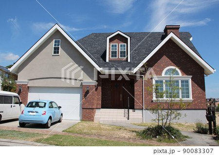 青空に映える北米スタイルでドーマーがあり煙突付きの赤レンガ調の大きな切妻屋根のおしゃれでかわいい邸宅 青空に映える北米スタイルでドーマーがあり煙突付きの赤レンガ調の大きな切妻屋根のおしゃれでかわいい邸宅 90083307