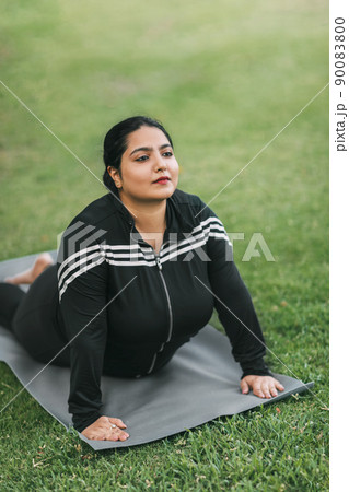 A beautiful Indian girl does yoga in a summer park. Healthy lifestyle. Various yoga poses. A beautiful Indian girl does yoga in a summer park. Healthy lifestyle. Various yoga poses. 90083800