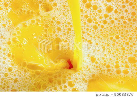 Closeup of splashing orange juice, top view. Splash of fresh sweet orange, mango, fruit juice. Closeup of splashing orange juice, top view. Splash of fresh sweet orange, mango, fruit juice. 90083876