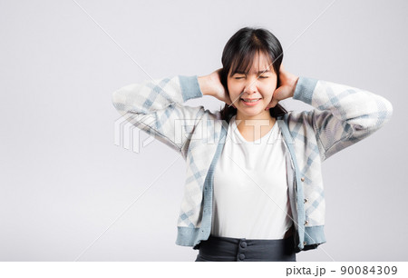 Woman bad mood pain her closed ears with hand palms and close eyes 90084309