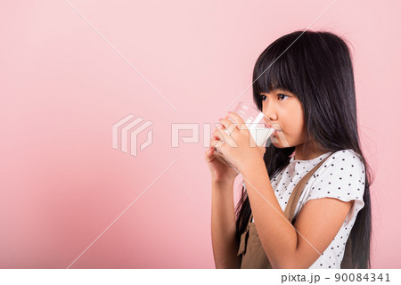 Asian little kid 10 years old smile hold milk glass drink white milk and drinking Asian little kid 10 years old smile hold milk glass drink white milk and drinking 90084341
